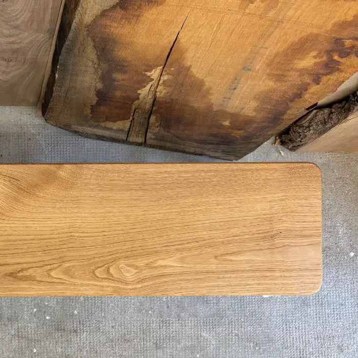 Extrémité droite de l'assise vue du dessus, à côté d'une planche brute aux teintes contrastées