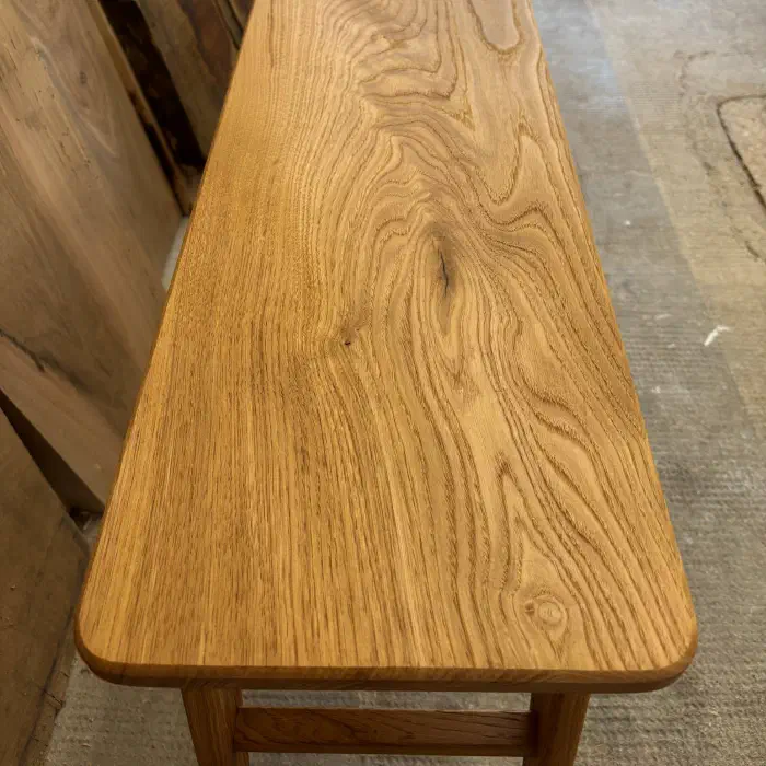 Assise du banc vue de trois quarts : veinage marqué du châtaignier et angles arrondis