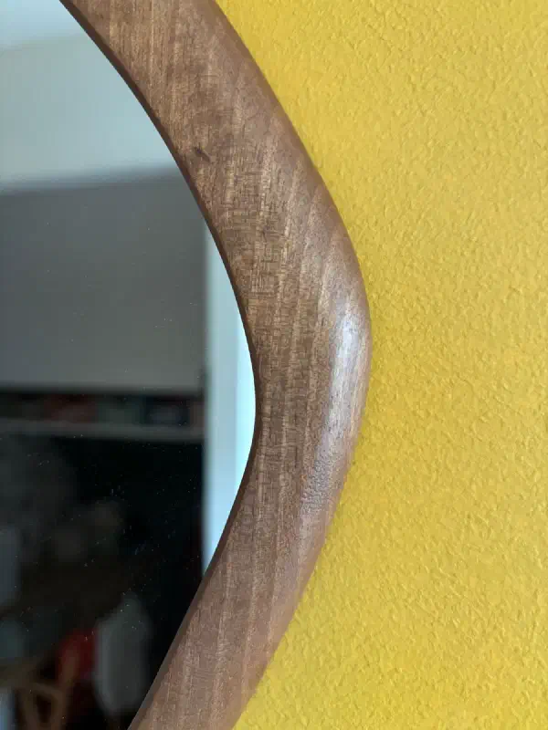 Courbe extérieure du petit miroir contre le mur jaune