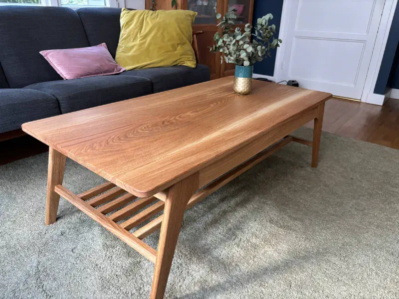 Table basse en chêne vue en plongée : veinage du plateau, angle arrondi, tablette à claire-voie