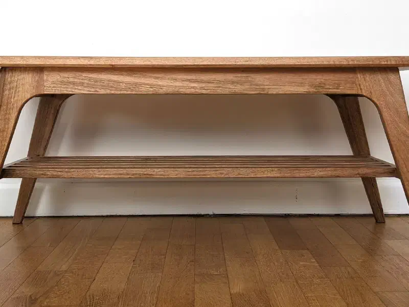 Table basse en noyer vue de face devant un mur blanc