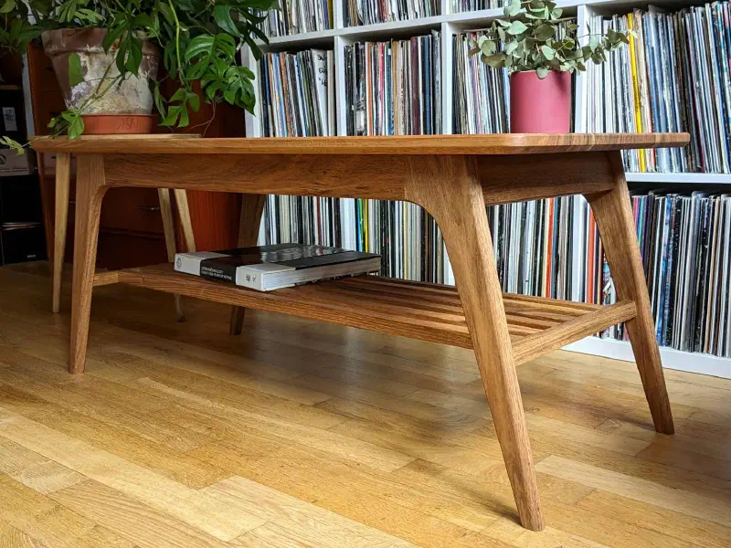 Table basse en noyer vue en contre-plongée : ceinture et pieds inclinés