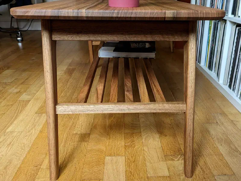 Table basse vue par le petit côté : pieds, traverse et lattes de la tablette